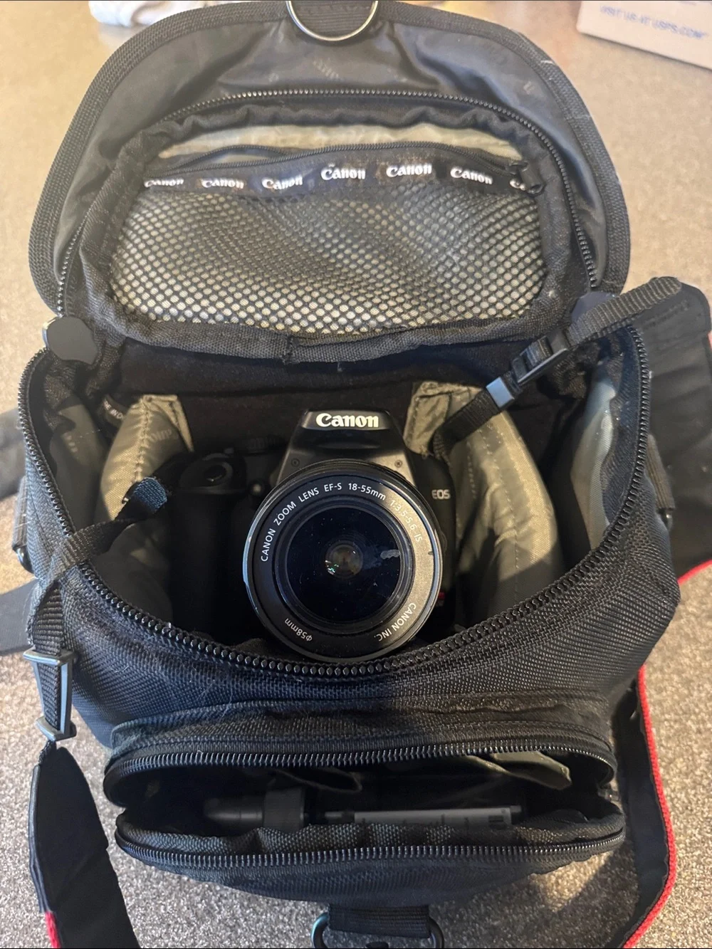 Canon DSLR Camera with Black Body and Red-Trim Strap and Camera Bag